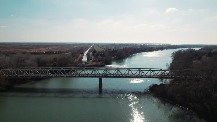 Veduta mozzafiato da drone: auto d'epoca che attraversano un bellissimo ponte nel sud della Francia, con vista sul fiume che scorre
