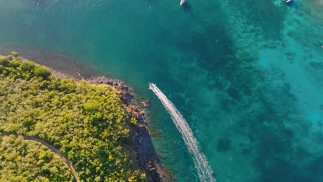 speed boat travels along island coast of beautiful tropical island during sunrise