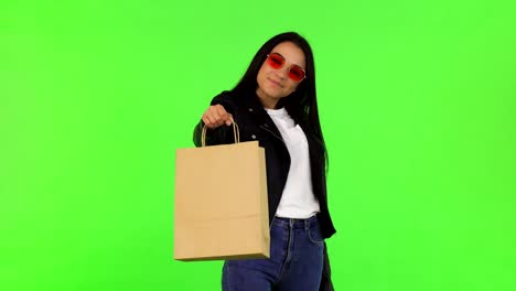 feliz mujer elegante y hermosa sosteniendo una bolsa de compras para la cámara
