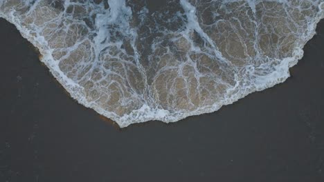 Aerial-establishing-view-of-Venta-river-rapids-during-winter-flood,-Kuldiga,-Latvia,-overcast-winter-day,-wide-ascending-birdseye-drone-shot