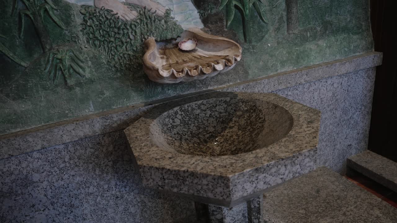 Close up of carved stone holy water font in religious interior