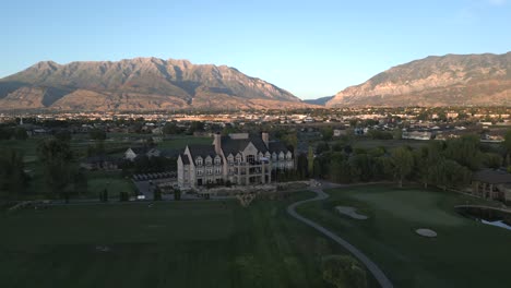 aerial forward shot of sleepy ridge clubhouse with mountain timpanogos and vineyard housing development, utah, usa