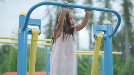 una madre embarazada y su hija joven disfrutan de un tiempo de juego juntos en un patio de recreo en el parque, rodeados de árboles y vegetación