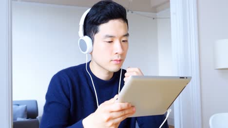 거실 4k에서 디지털 태블릿에서 음악을 듣고 있는 남자