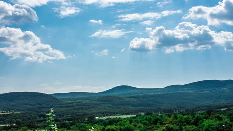 time-lapse clouds moving and blue sky over green hills