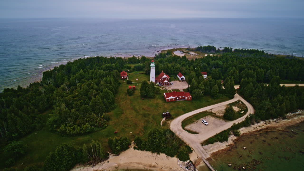 Drone shot panning around lighthouse on the shore of lake Michigan