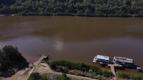 Toma-De-Drone-De-Un-Gran-Río-Marrón-Con-Colinas,-árboles-Y-Arbustos,-Barco-Fluvial,-Hawkesbury,-Nueva-Gales-Del-Sur