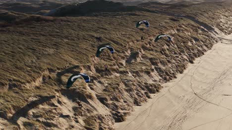 parapenteando sobre las dunas de arena en la playa