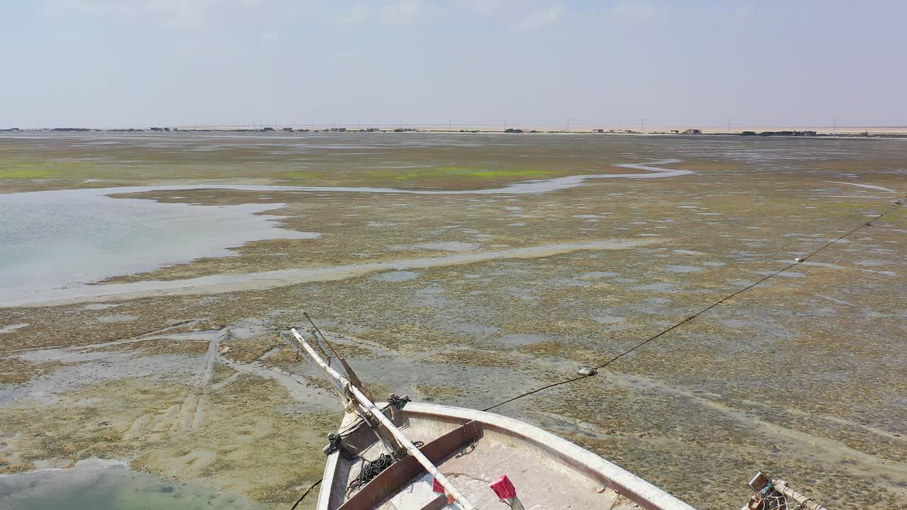 Drone shot of a deserted boat on the shore of the shallow water