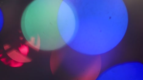 fuera de foco, las luces de colores de navidad arden y se mueven misteriosamente.