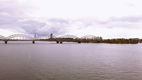 Cargo-train-transporting-wagons-across-the-iron-train-bridge-in-downtown-of-Rige-city,-Latvia