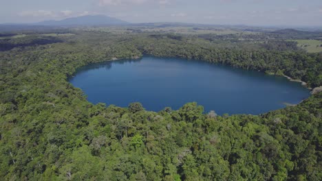 lago eacham rodeado de exuberante vegetación en atherton tableland, queensland, australia - toma aérea de drones