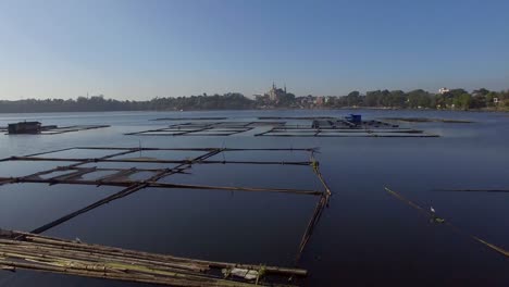 bamboo hut structure for local aquaculture provide domestic food needs of small rural farming community in sampaloc lake, laguna. drone, aerial shot