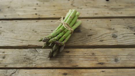Video-of-fresh-asparagus-bundle-on-wooden-background