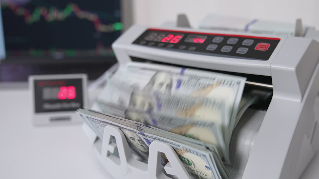 Small compact cash counting machine calculating American dollars. Equipment for financial operations. Close up.