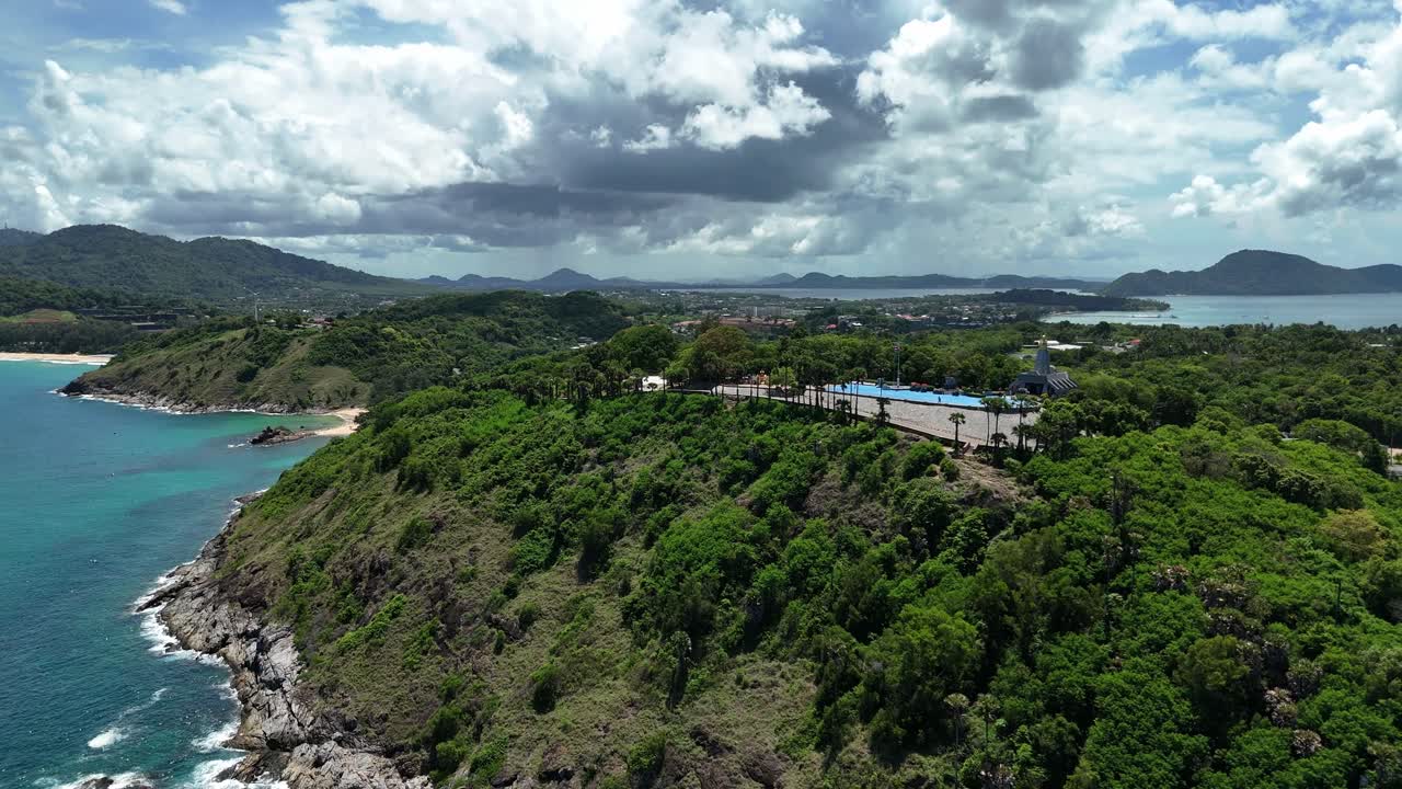 Aerial view of a scenic coastal landscape with a swimming pool on a hillside