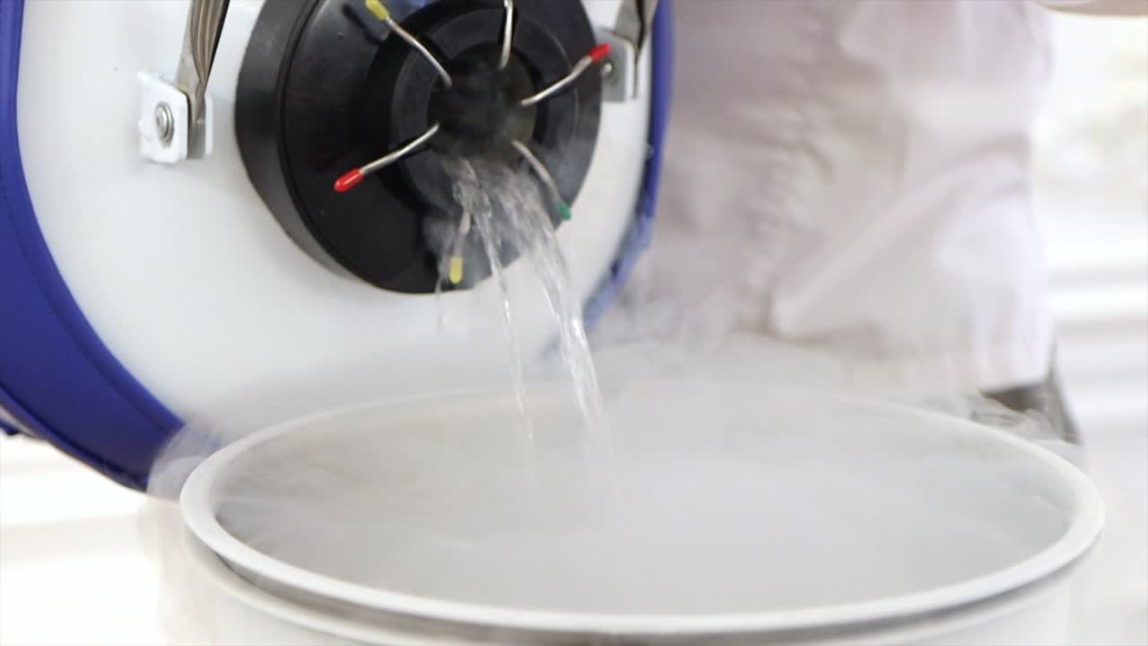 liquid nitrogen is poured from special barrel into steel saucepan in slow motion
