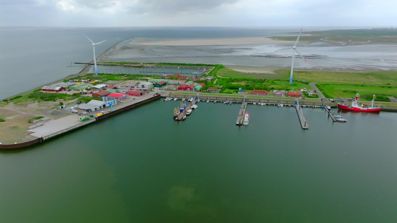 Panoramic view of Borkum harbor with docked boats, overlooking Wadden Sea UNESCO ecosystem tidal landscape