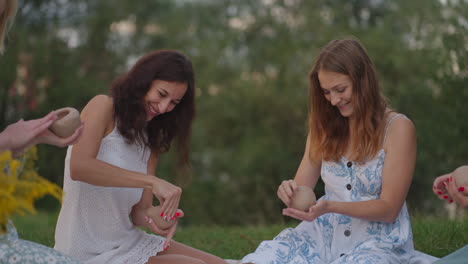 a group of young women are sculpting from clay laughing communicating in nature in the field in the open air. the master explains the correct technique of sculpting. creative activities hobby.