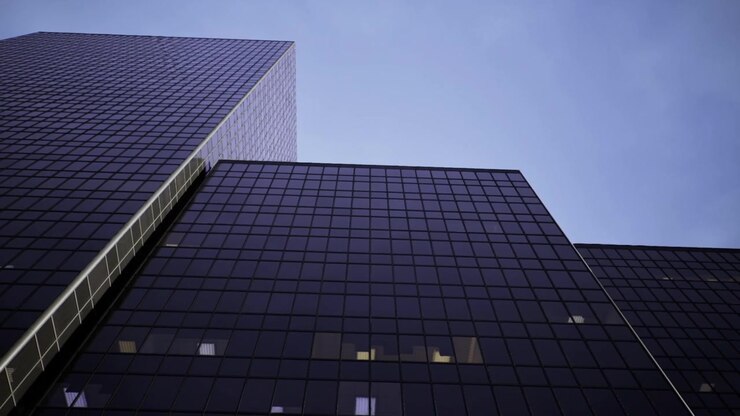 Edifici a specchio sotto il cielo mostrano drammatici motivi geometrici riflettenti.