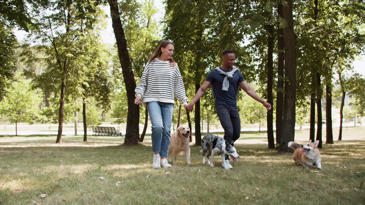 una pareja joven con mascotas en el parque.
