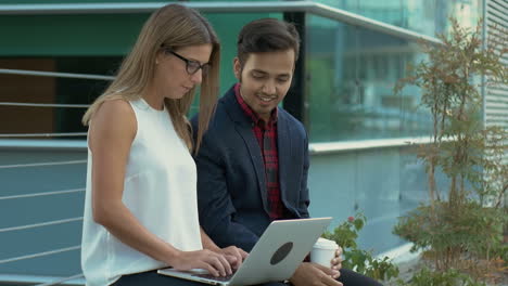 multiethnic business people using laptop outdoor