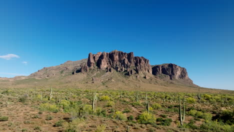 gradual establishing shot above saguaro cactus and sandy desert southwest landscape to superstition mountains