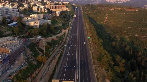 aerial view of a long highway winding through urban and natural landscapes