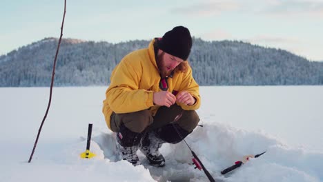 man is putting bait on the rod