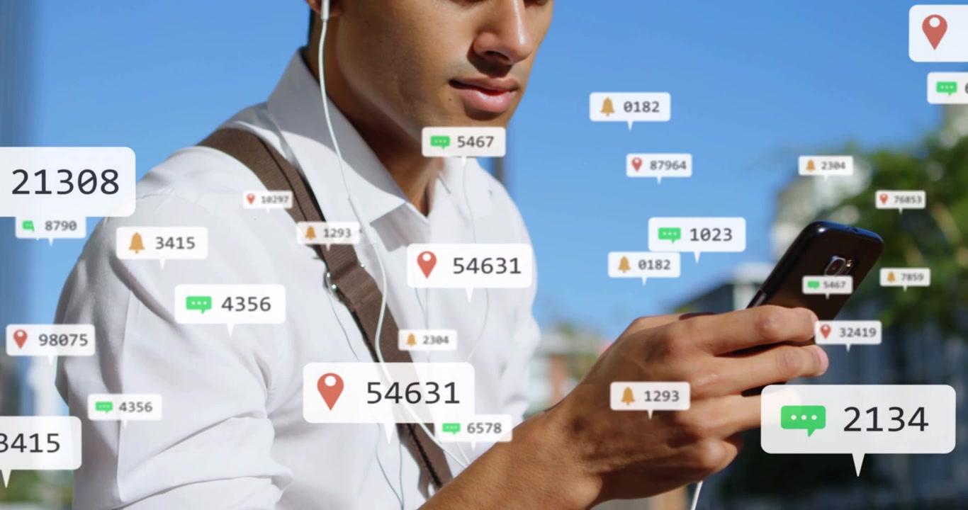 Muž v košili s hnědým popruhem na chodníku kontroluje telefon s bílými drátovými sluchátky, zatímco se shlukují upozornění.