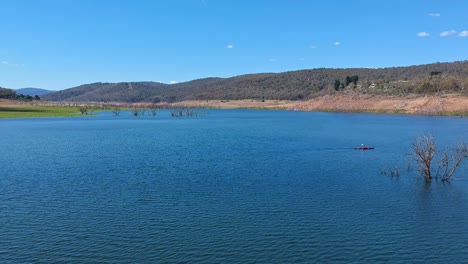 descending footage of a kayaker paddling on lake eucumbene