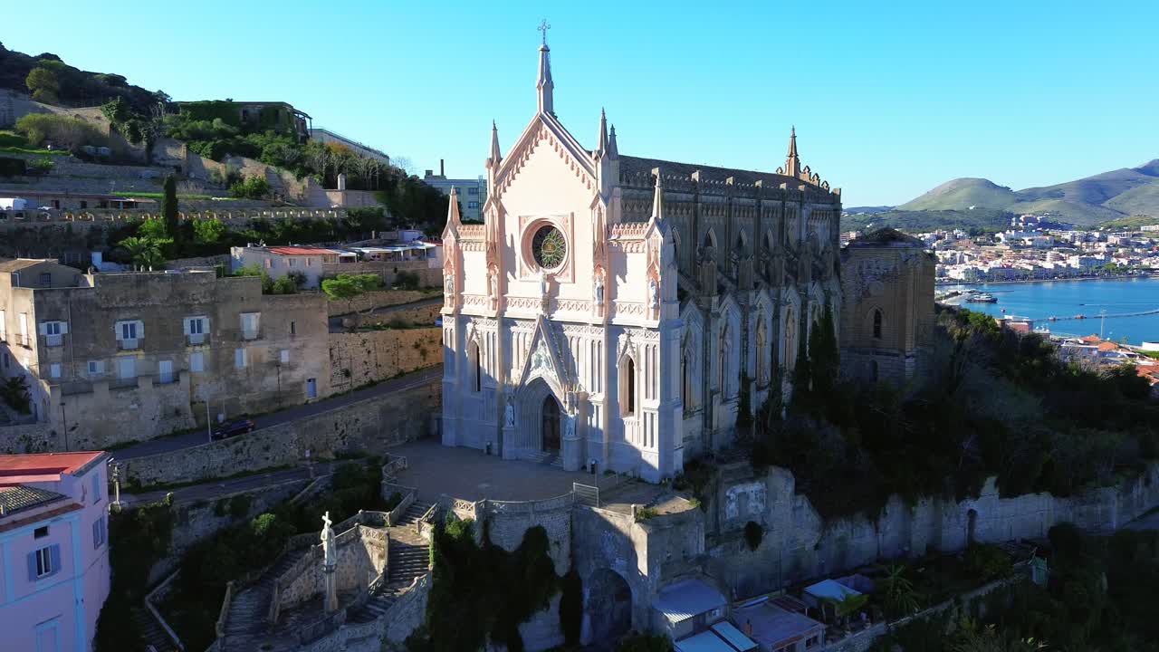 histórica iglesia costera tempio de san francisco y frente al mar en gaeta, lazio, órbita aérea, bajo un cielo azul claro.