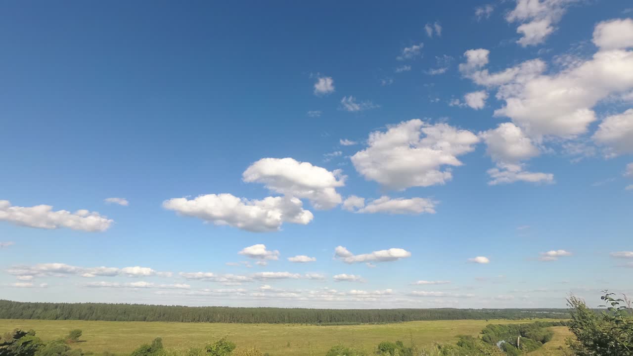 nubes blancas esponjosas corriendo a través del cielo sobre los campos lapso de tiempo 4k imágenes, bucle