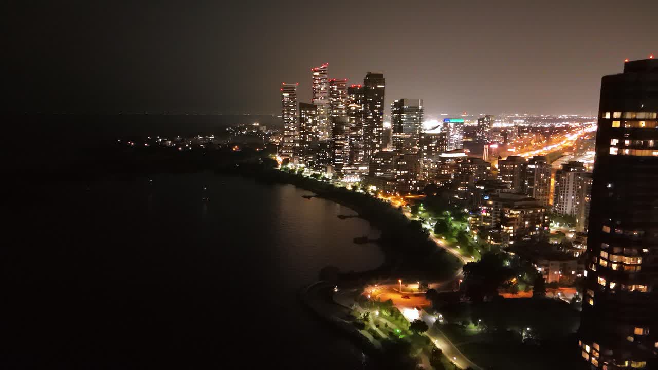 Parklawn and Humber Bay neighborhood with city lights in Toronto, Canada, night aerial dolly