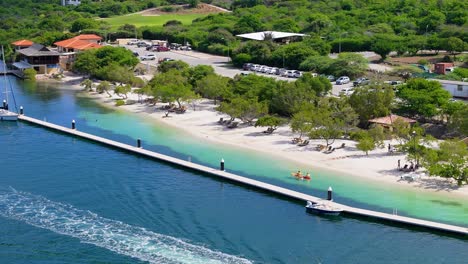 Boats-docked-on-pier-protects-beach-side-sunbathers-and-swimmers-on-beautiful-day-in-the-Caribbean