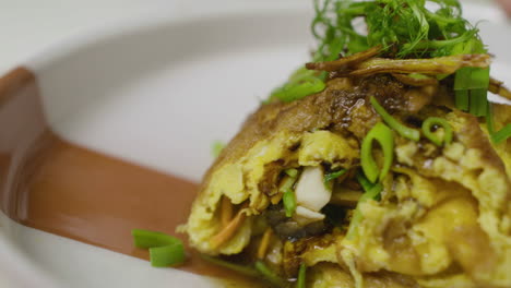 Close-up-on-abalone-and-egg-dish,-decorated-with-greens-on-top