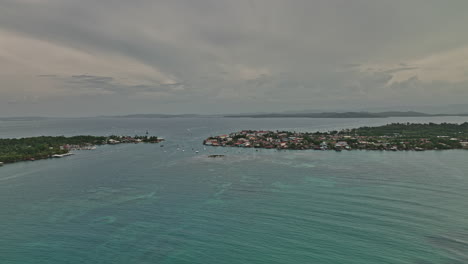 Vista-Aérea-De-Bocas-Del-Toro-Panama-V14-Vista-Exótica-De-Verano,-Sobrevuelo-Hacia-Una-Pequeña-Ciudad-Isleña-Capturando-Veleros-Y-Yates-Navegando-En-Hermosas-Aguas-Turquesas---Filmado-Con-Cine-Mavic-3---Abril-De-2022