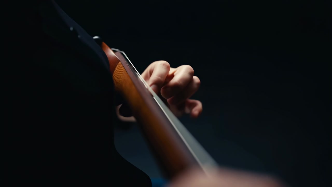 Right hand carefully manipulates metal receiver on polished wooden gun stock, fingertips curling inward and pressing along edge to show precise adjustment, tactile control, dark studio contrast, and