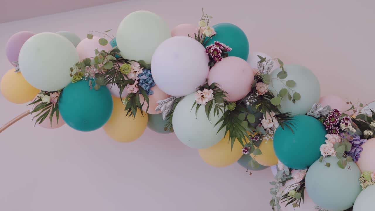 arco de globos decorativo de boda en colores pastel con detalles florales que crea un ambiente festivo y encantador