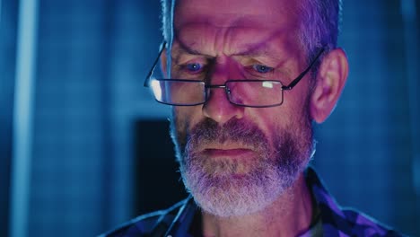 close-up of a man wearing glasses and looking intently