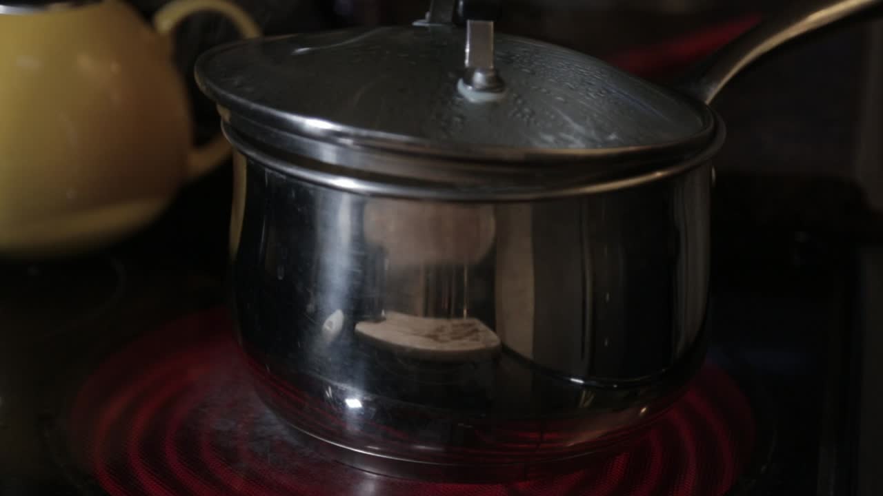 A Steaming Hot Pot With Slightly Opened Glass Cover - Close Up Shot