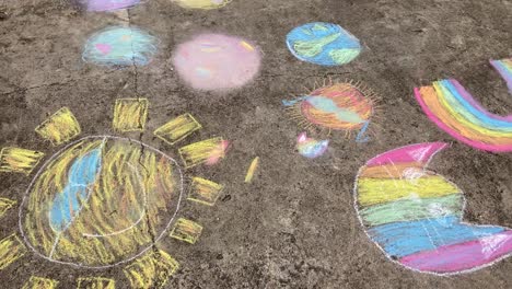 panning shot of a child's playful chalk artwork on sidewalk, summer creativity background