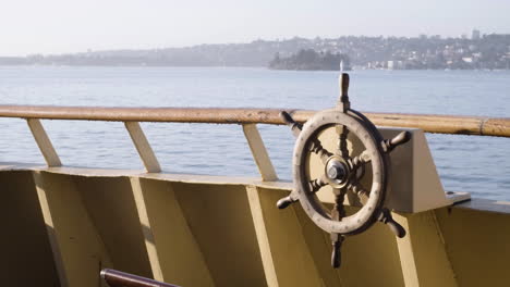 Boat's-Wheel-On-Railings-Of-Boat-Sailing-At-Port-Jackson-Bay,-Sydney-Harbour-In-Sydney,-New-South-Wales,-Australia