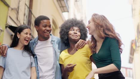 diverse group of happy friends laughing and walking on a city street