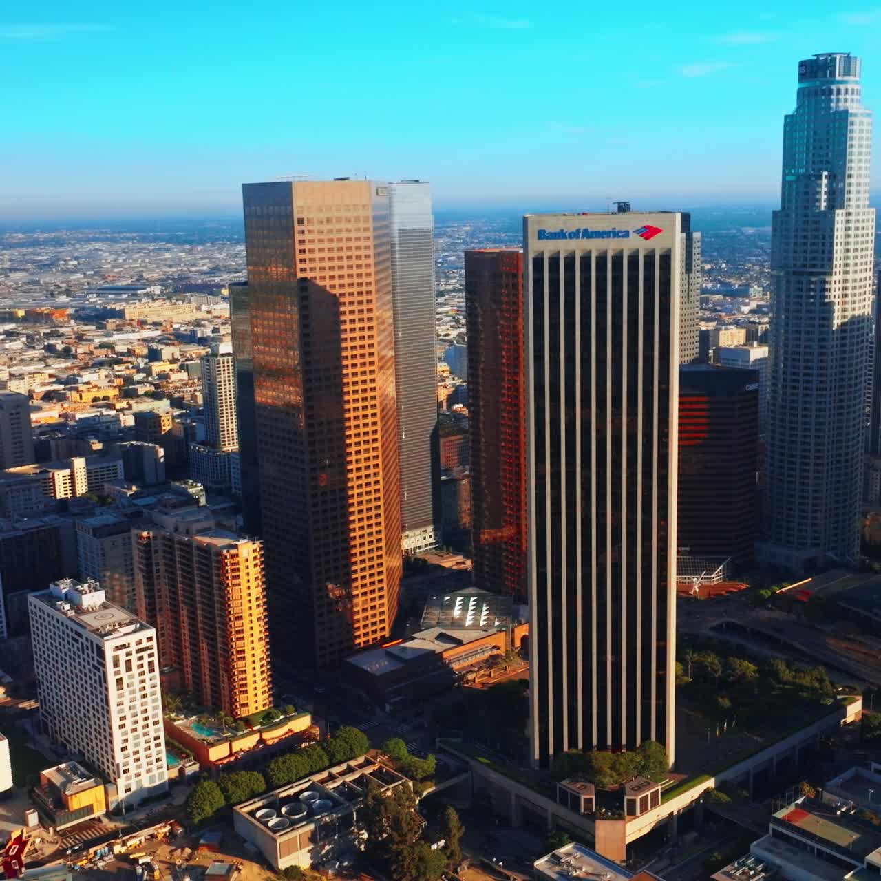 Footage at the level of skyscrapers of sunny Los Angeles. Contemporary diverse buildings at the backdrop of low architecture of the city
