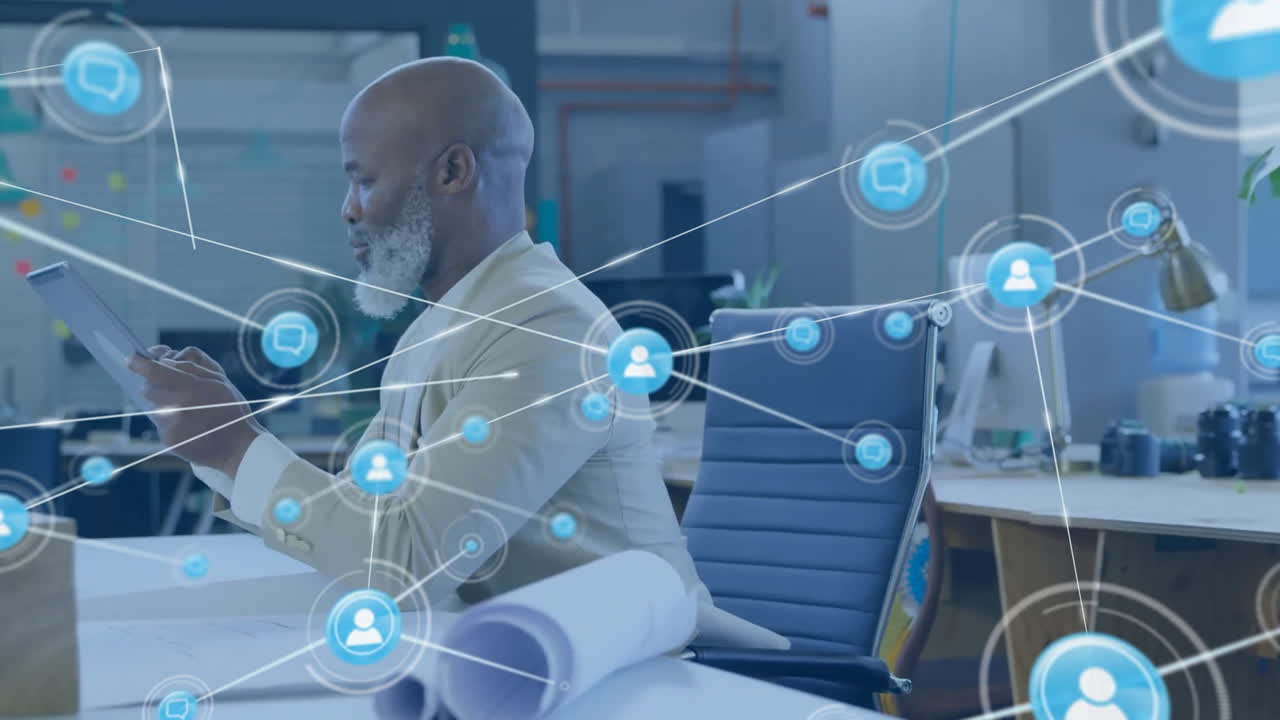 Animation of network of connections with icons over african american businessman using tablet