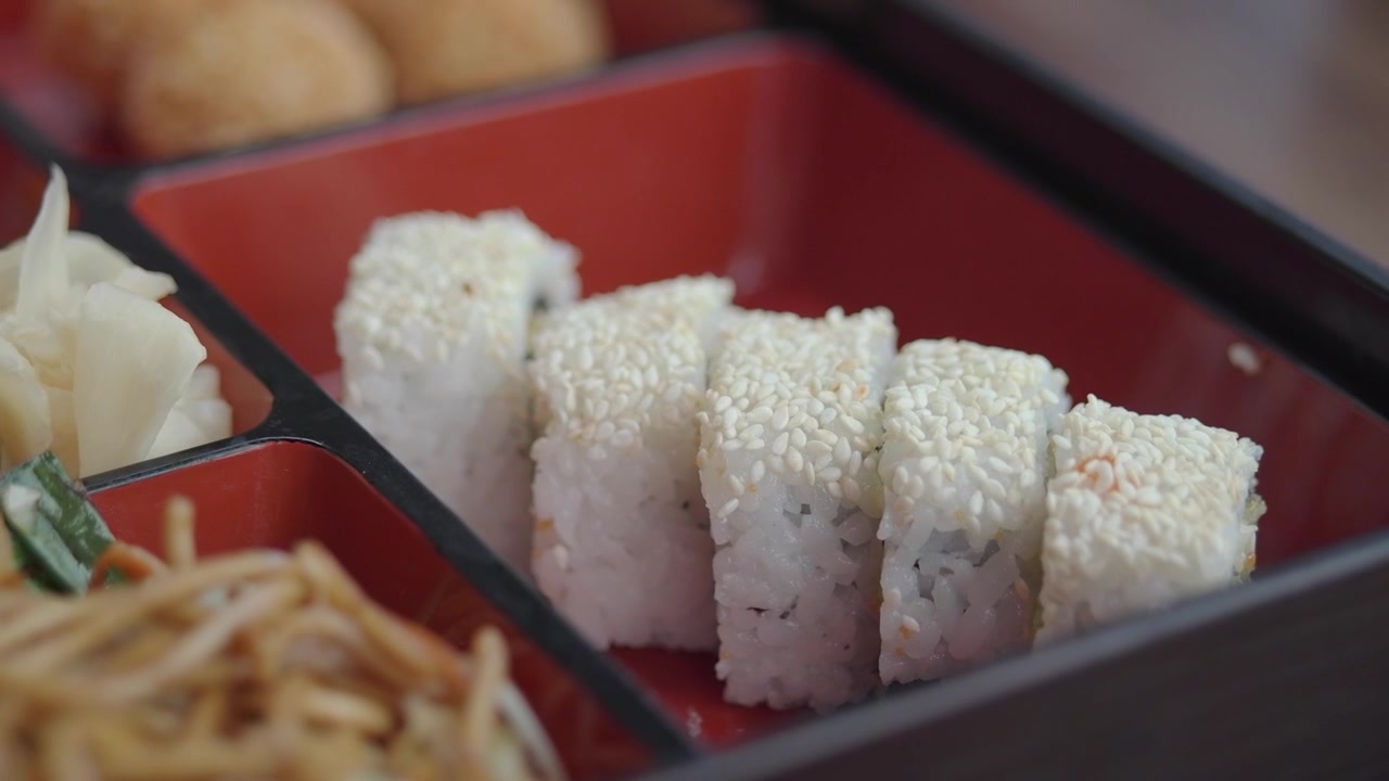 Nahaufnahme von Sushi-Rollen in einer traditionellen Bento-Box