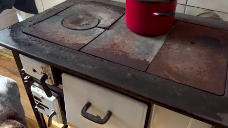 Old-charcoal-cooker,-a-historic-piece-of-kitchen-equipment-with-red-pots-on-top