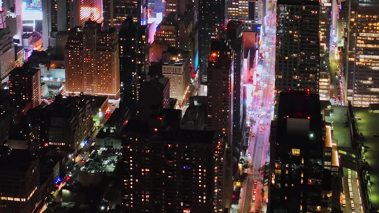 Nighttime aerial view of vibrant New York City illuminated by city lights