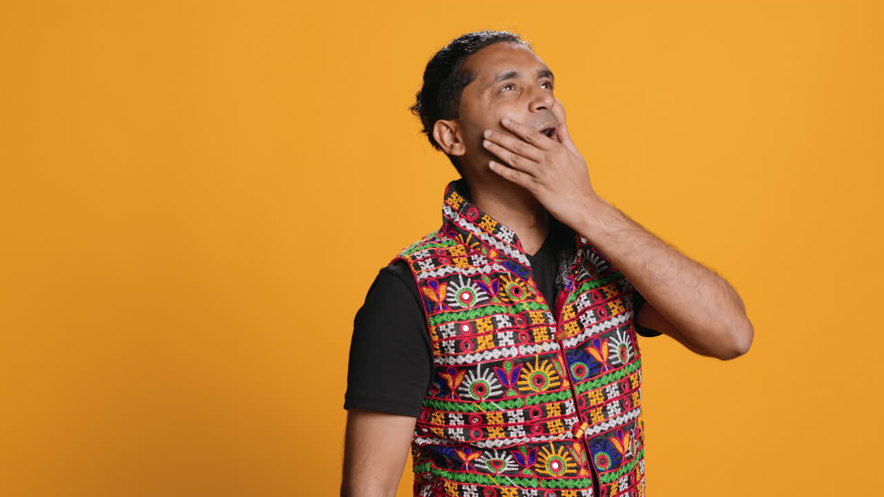Exhausted person yawning, drinking coffee, isolated over studio background